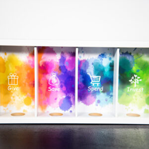 Bank of Me' piggy bank showcasing a clear front window displaying four separate slots for Give, Save, Spend, and Invest, designed to help children learn about saving.