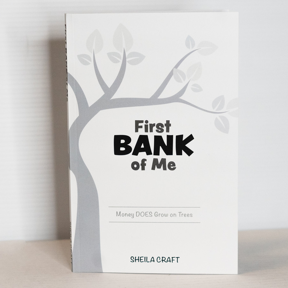 'First Bank of Me' book cover, featuring a clean white background with a grey tree and the title, along with the quote 'Money does grow on trees.'
