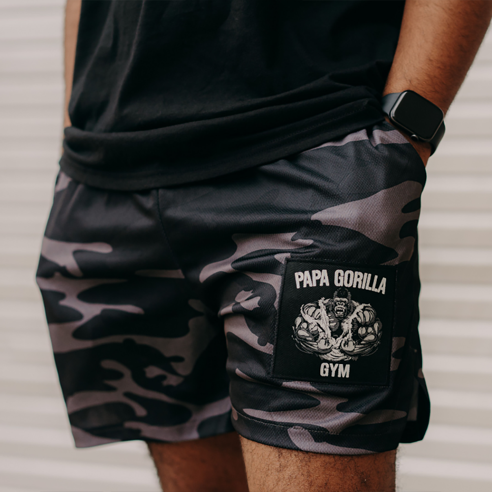 Close-up of camo shorts featuring the 'Papa Gorilla' logo on the leg.